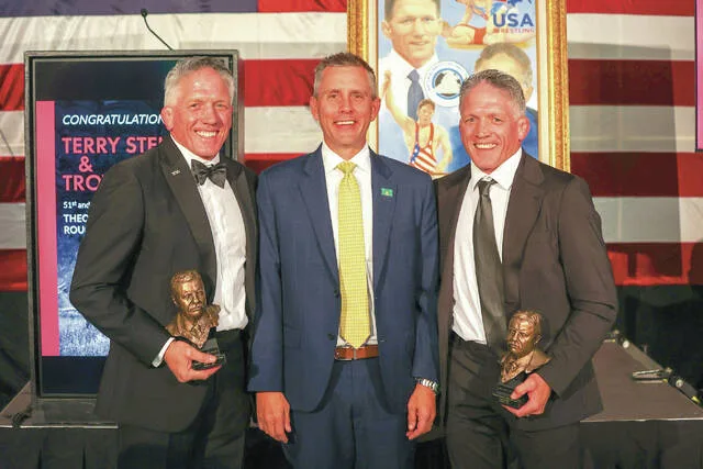 Armstrong presents Rough Rider Award to twin brother wrestling coaches Terry and Troy Steiner